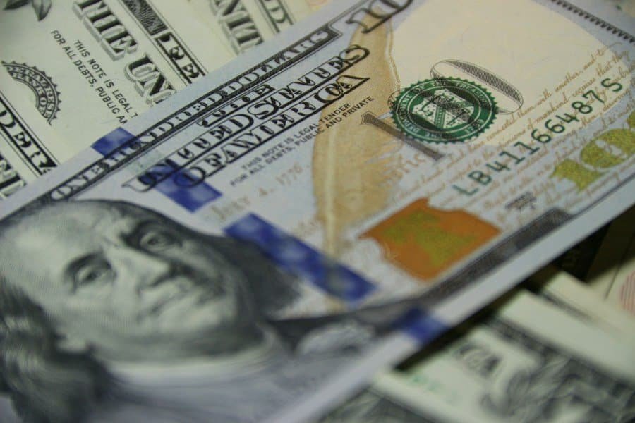 A pile of us dollar bills on a table.