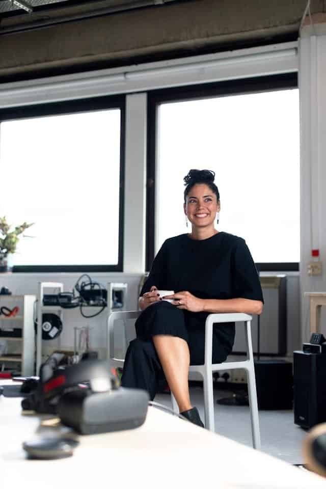A woman sitting on a chair in an office.